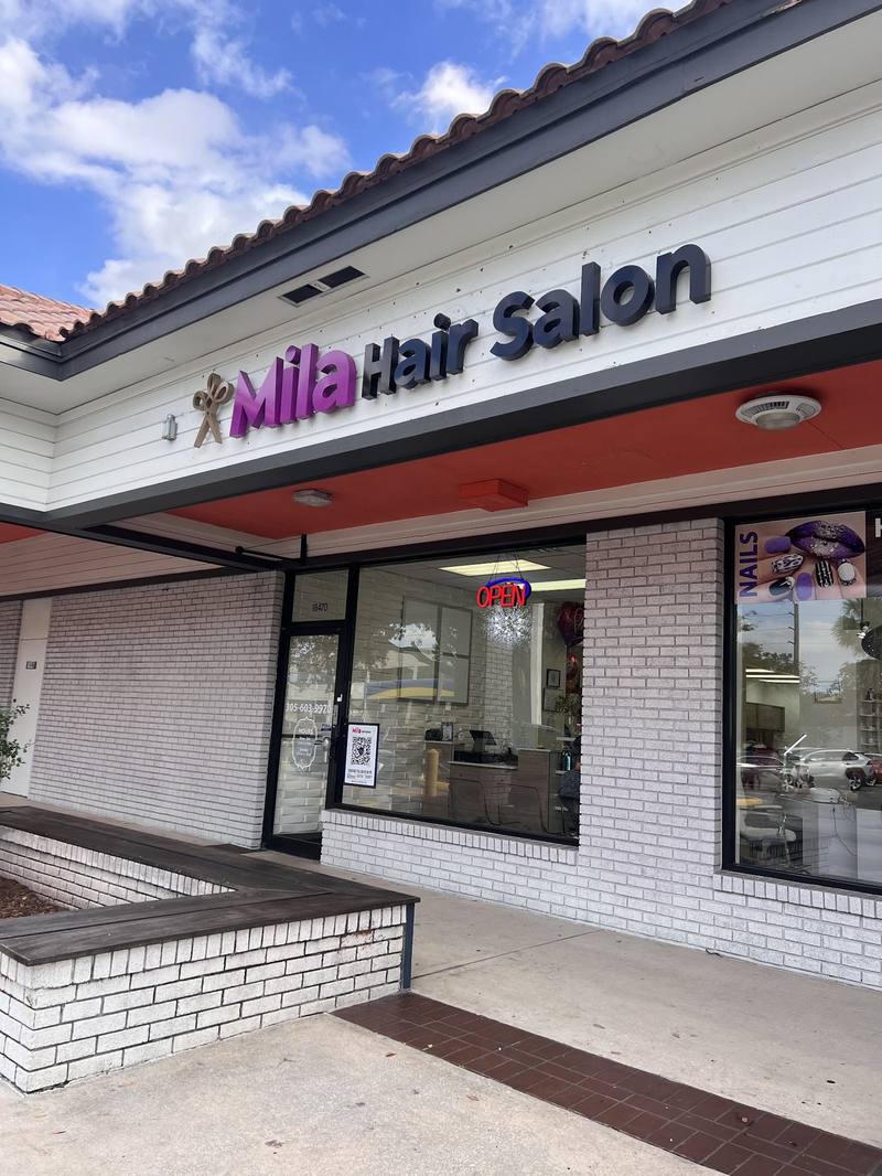 La entrada del salón, desde el parqueo: el letrero de Mila Hair Salon sobre la puerta
